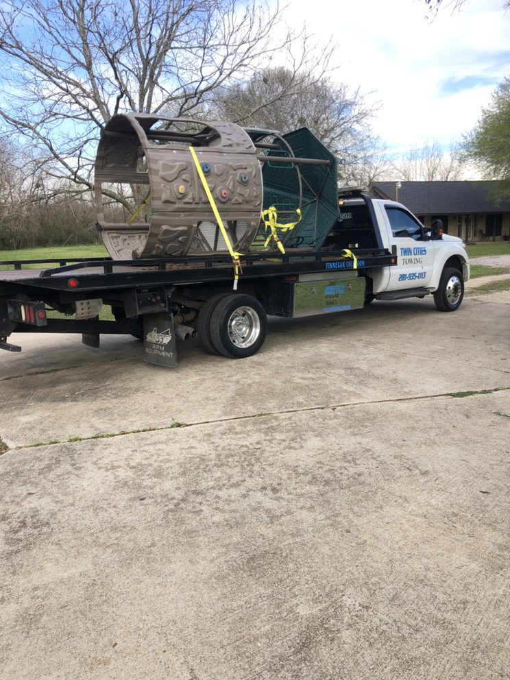 Tow truck operator securing a car for transport in Richmond, TX — breakdown of local towing costs and per-mile rates